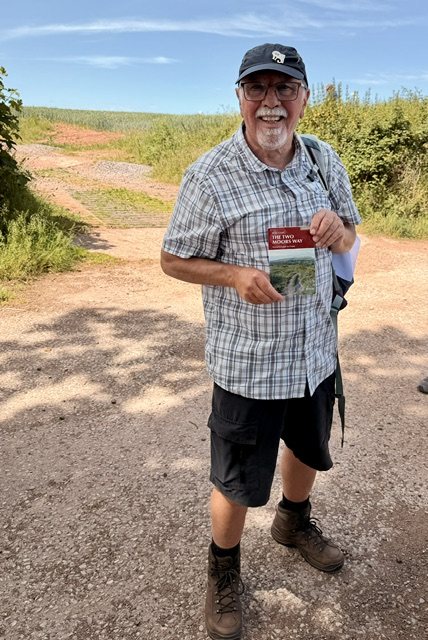 Les Bright holding the official Two Moors Way guidebook